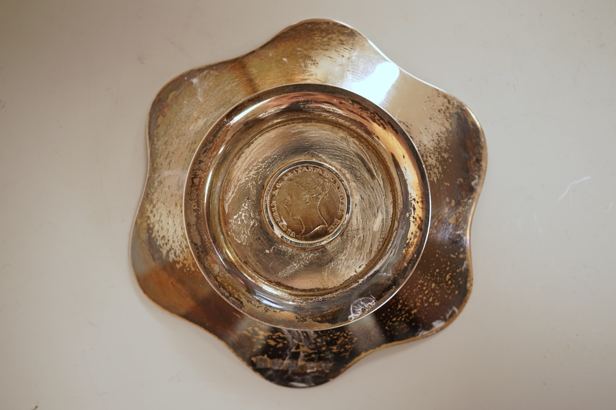 A cased set of four George V silver flower head shaped nut dishes, each inset with an 1850 maundy coin, Walker & Hall, Birmingham, 1936, diameter 77mm.